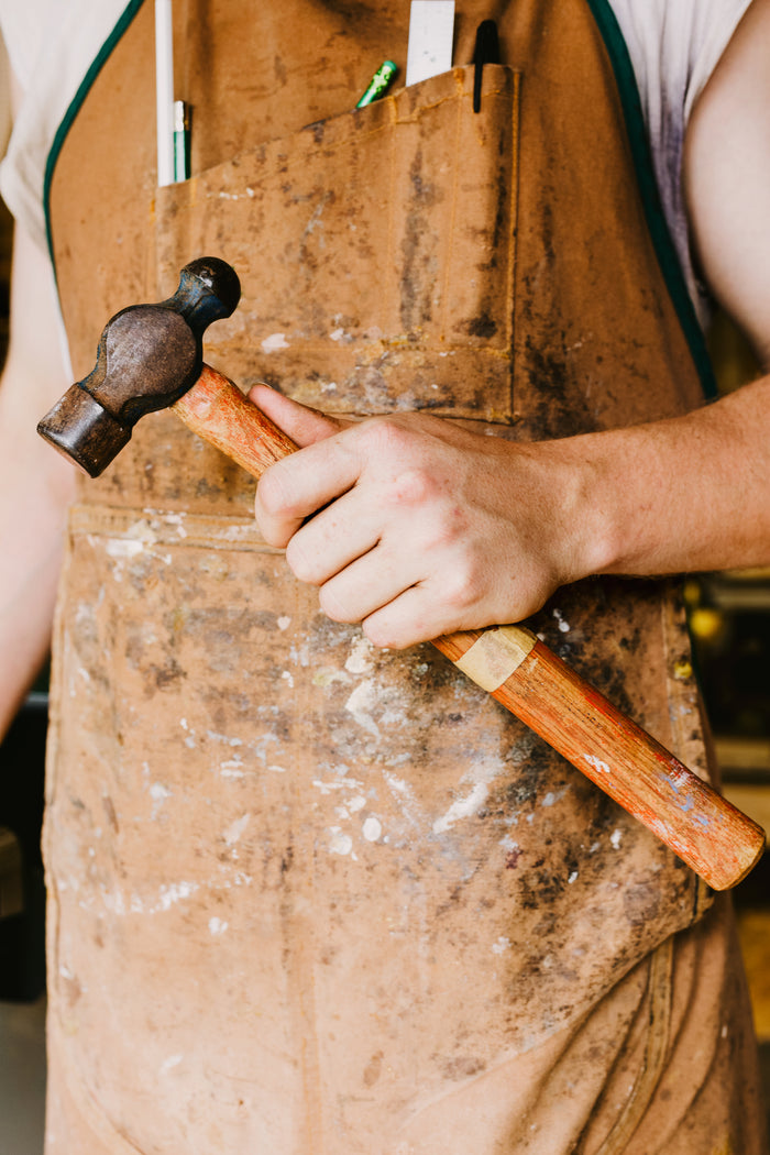 This is an image showing a man holding a hammer